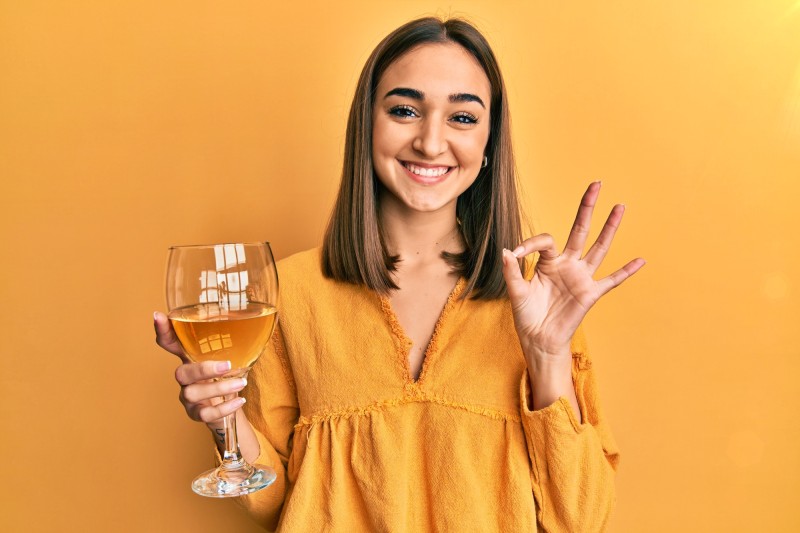 chica con una copa de orange wine