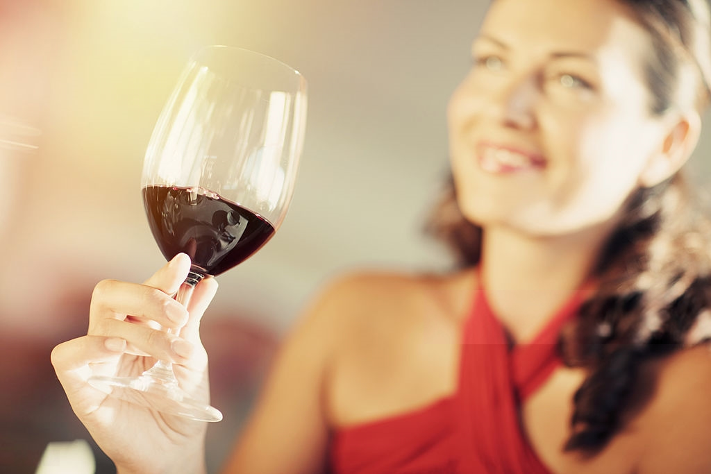 Young girl drinking red wine