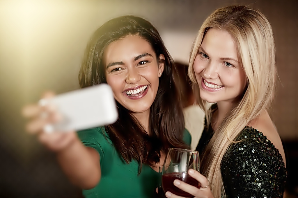 Dos chicas tomando vino se hacen una selfie