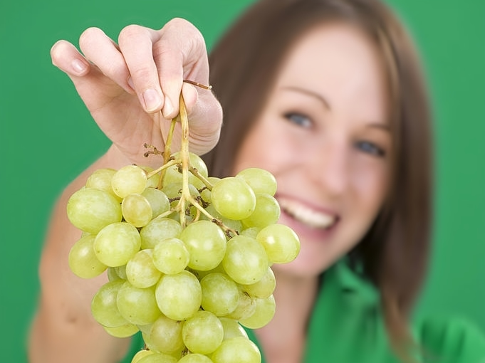 Chica muestra un racimo de uvas
