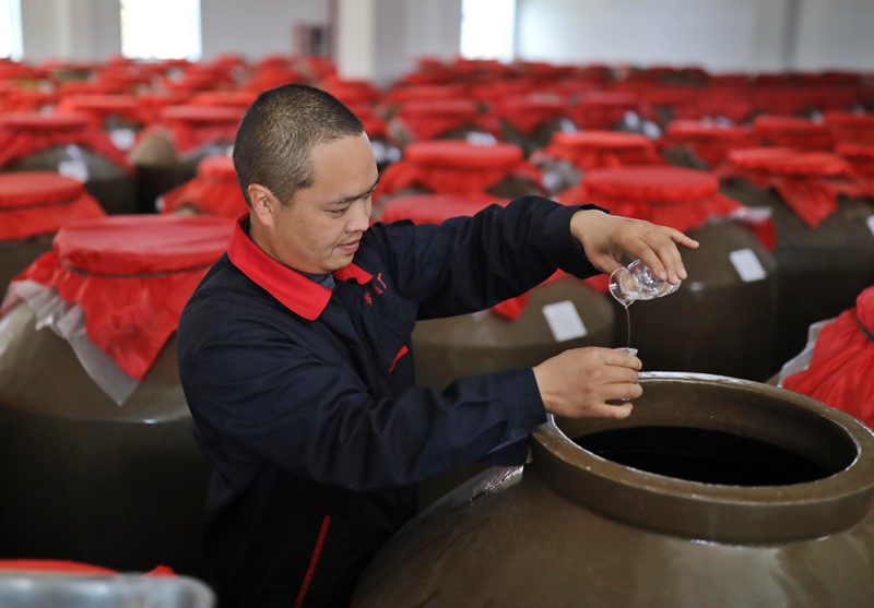 Un trabajador chino comprueba baijiu, en una bodega de producción en la ciudad de Bijie, provincia de Guizhou, al suroeste de China