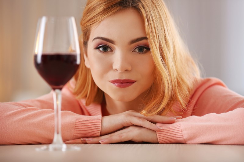 mujer mira copa de vino