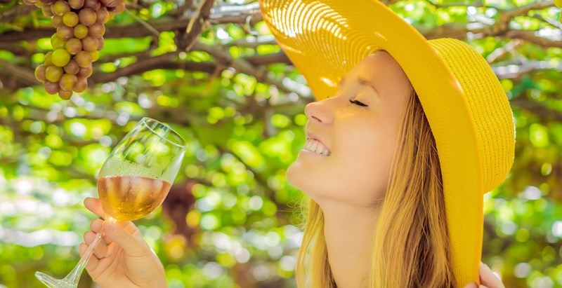 una mujer en el viñedo con un vino naranja u orange wine