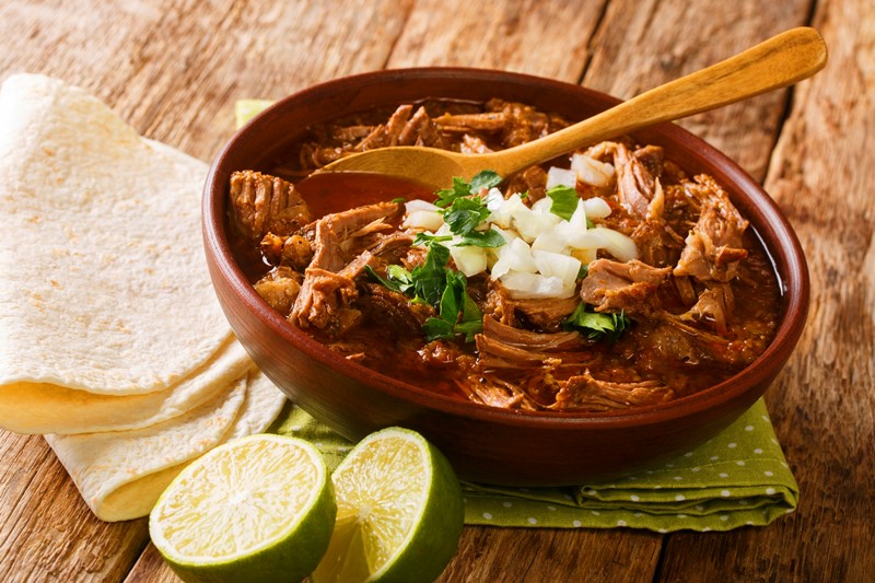 Birria caliente servida con lima