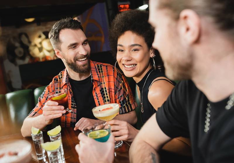 amigos en un bar bebiendo cócteles, licores y destilados